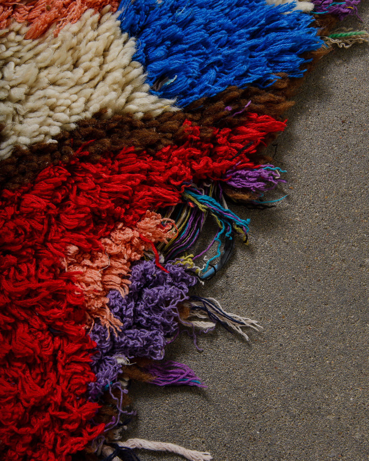 Close up of edge of vintage rug showing where the weaving has come undone.